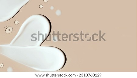 cosmetic smear of cream in the shape of a heart on a beige background with a place for text