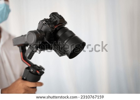 Photographer's hand holding a wedding video camera	