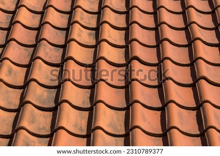 Red roof tile pattern over blue sky