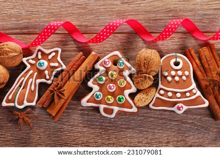 christmas wooden background with homemade gingerbread cookies ,spices and red ribbon