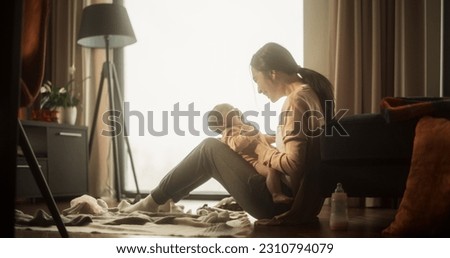 Mother and Baby Bonding Moment: Authentic Shot of an Asian Woman New to Motherhood Playing with her Cute Child in the Morning at Home. Cozy and Warm Atmosphere for a Mother and her Infant Royalty-Free Stock Photo #2310794079