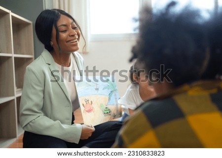 Teacher tells a story to the children in class. She showing pictures to student in classroom.