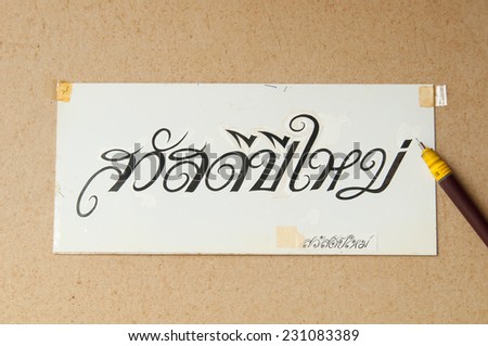 Write thai text the words "Happy New Year" on white paper