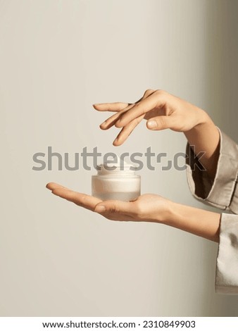 Gently dip your fingers in the skin care face cream cream and hold it Royalty-Free Stock Photo #2310849903
