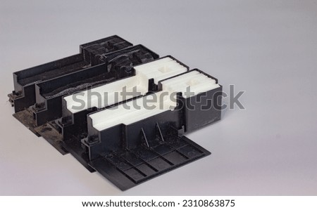 Printer waste ink absorber box laying on white background