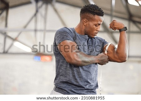 Black man, tape measure and bicep with muscle and strong athlete, weightlifting and fitness in gym. Power, challenge and arm measurement, male person with exercise and bodybuilding with mockup space Royalty-Free Stock Photo #2310881955