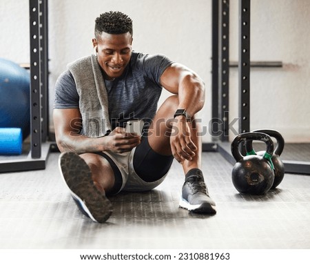 Fitness, phone and black man typing in gym on break after exercise, training or workout. Athlete, smartphone and happy African male person on sports app, networking or social media, email and relax. Royalty-Free Stock Photo #2310881963