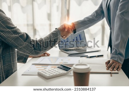2 businesswomen shaking hands in the office Team collaboration A successful and confident businesswoman shakes hands with her business partners. Welcome, congratulations, cooperation.Remote Picture
