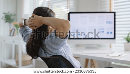 Asia people workforce young woman remote work at home office sit easy relax enjoy break time life balance put hands behind head and lean back on cozy desk. Teen girl stress relief look at desktop PC.