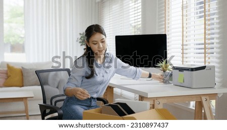 Future of workforce remote work fully permanent. Asia people happy relax move job to new small workspace set up desk picking file folder from box. Keep it chores neat start long term plan career work. Royalty-Free Stock Photo #2310897437