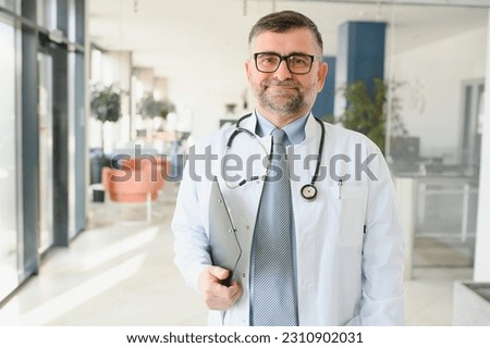 Portrait of senior doctor in white coat.