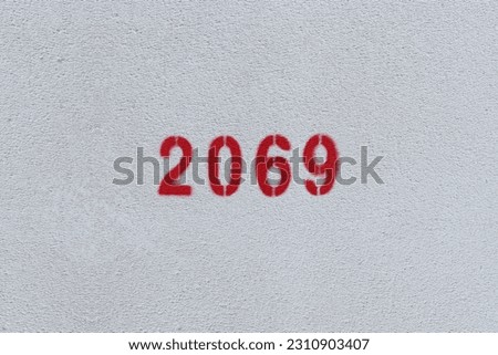 Red Number 2069 on the white wall. Spray paint.
