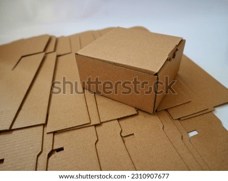 Brown cardboard or paper box on the top of die cut paper box isolated on white background. Mock up, copy space. Royalty-Free Stock Photo #2310907677