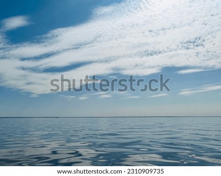 Glance and shining sea surface, seascape, bright blue sky with some clouds 
