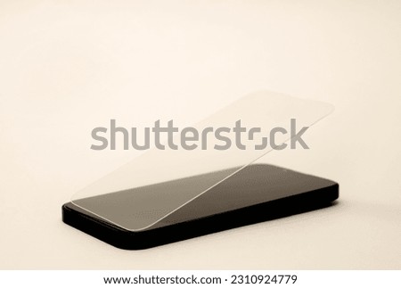 glass film change,repair and maintenance smartphone.hand in glove holding screen protection.flying in air tempered glass and phone.tools and display napkin Royalty-Free Stock Photo #2310924779