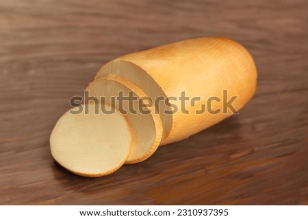 Provolone cheese  with cut slices on top of beautiful wood Royalty-Free Stock Photo #2310937395