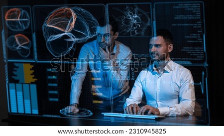 Two Caucasian bearded men are discussing medical screen of a virtual menu. Human brain research. 