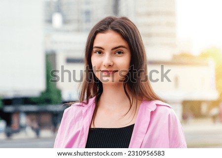 Street portrait of beautiful caucasian young woman with long hair. Authentic people outdoor photo concept.