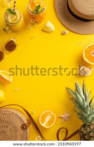 Relax and unwind with refreshing summer cocktails. This top vertical view flat lay highlights a bag, sunhat, pineapple, cocktails, and citrus fruit on a bright yellow background, with a blank circle Royalty-Free Stock Photo #2310960197