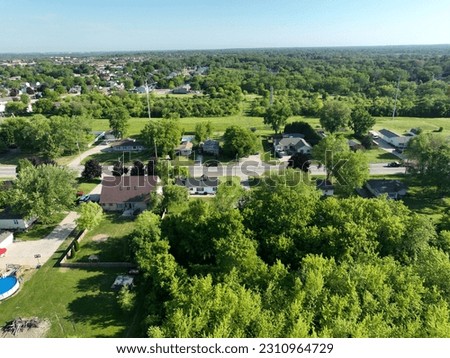Aerial photography captures the sprawling green landscape and estate of residential buildings from a birds-eye view. The intricate architecture stands out in the day environment.