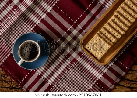 Rustic noble wood table with a cloth over cookies or milk biscuits with coffee