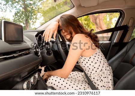 Asian woman sleeping in the car due to her exhaustion evident from the long drive. Concept of driving, travel and vacation