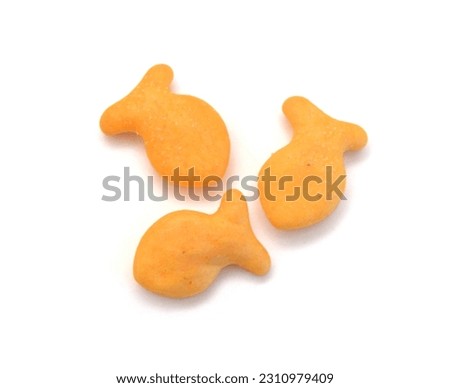 A scaterring of yellow goldfish crackers in glass bowl on white Royalty-Free Stock Photo #2310979409