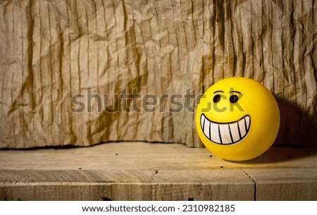 Yellow emoticon rubber toys  with facial expressions isolated in wooden background , design for card , world emoji day 
