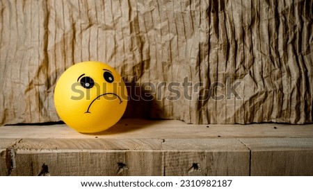 Yellow emoticon rubber toys  with facial expressions isolated in wooden background , design for card , world emoji day 