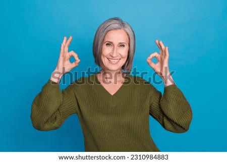 Photo of beautiful senior business lady show okey symbol hands express approval wear khaki sweater isolated blue color background