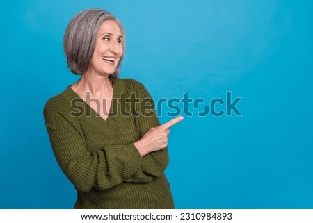 Portrait of optimistic person with gray hairdo wear knit pullover indicating look empty space sale isolated on blue color background