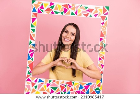Photo of adorable sweet lady wear yellow t-shirt tacking photo colorful border showing arms heart isolated pink color background