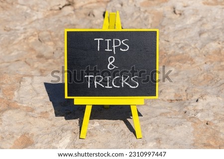 Tips and tricks symbol. Concept words Tips and tricks on black chalk blackboard on a beautiful stone background. Business and tips and tricks concept. Copy space.