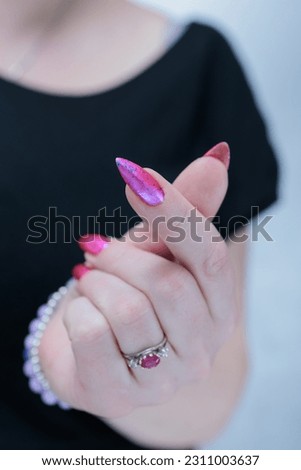 Woman hand with long nails manicure and light pink and blue nail polish