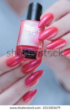 beautiful female hands with long nails and bright neon pink and red nail polish