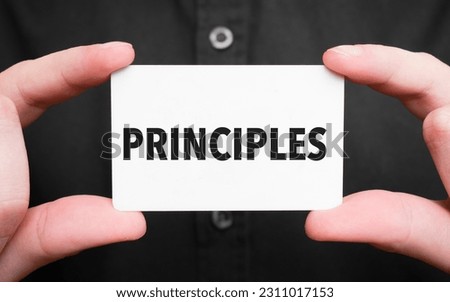 Businessman holding a card with text PRINCIPLES, business concept