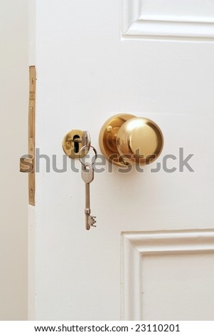 Close up of golden key at white door Royalty-Free Stock Photo #23110201