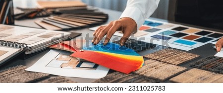 Interior architect designer at workstation table choosing various color samples art tool design with home blueprint. Creative color selection for house renovation or design concept. Insight Royalty-Free Stock Photo #2311025783