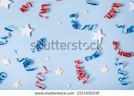 USA Independence day concept. Red and blue spirals and white stars elements of USA flag top view, flat lay on blue background.