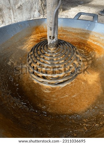 The process of stirring Toddy palm sugar  Royalty-Free Stock Photo #2311036695