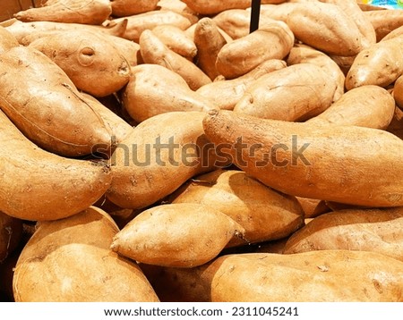 Grocery store sweet potatoes in a pile on display