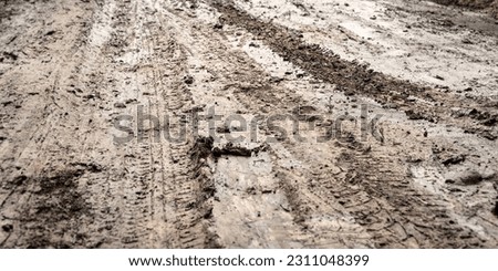 Off-road. Dirty wet dirt road. Tire tracks. Rut on a muddy road. Wheel tracks on the ground. Clay surface. Bad weather Royalty-Free Stock Photo #2311048399
