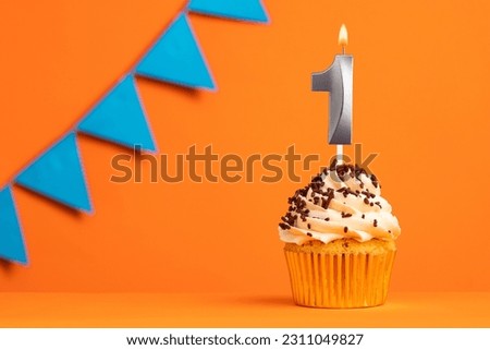 Candle number 1 - Cake birthday in orange background Royalty-Free Stock Photo #2311049827