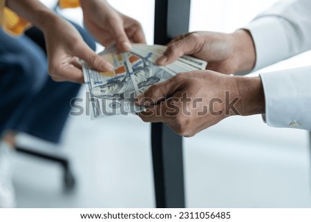 Businesswoman hand holding bribe money to government officials sign contracts for business projects, put money under envelope, ideas of corruption and anti-bribery. Royalty-Free Stock Photo #2311056485