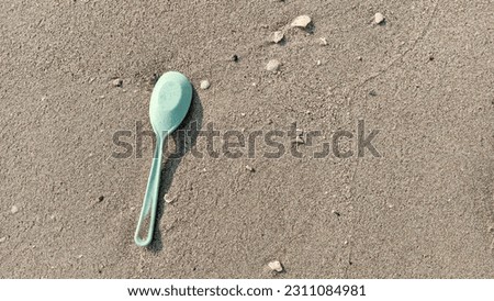 Environmental pollution and water microplastic. Microplastic with spoon in the seaside sand. Microplastics are contaminated in the sea. Microplastic problem.Threat to human health and the environment.