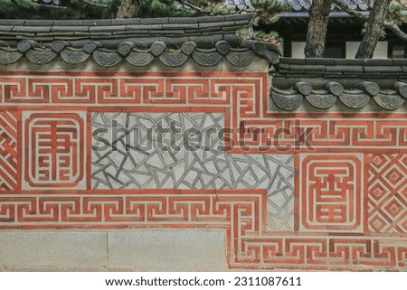 Afternoon view of red patterns on the wall with tile roof at Unhyeon Palace of Jongno-gu, Seoul, South Korea
