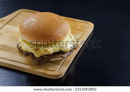 Barros Luco sandwich popular in Chile: beef with melted cheese. on black table and wooden board with copy space concept of typical Chilean food Royalty-Free Stock Photo #2311093893