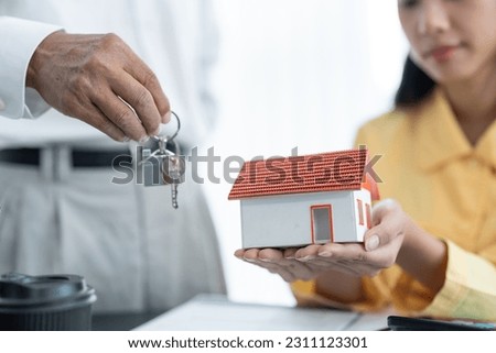 Real estate agent holding house model and keys, customer signing contract to buy house, insurance or loan real estate.