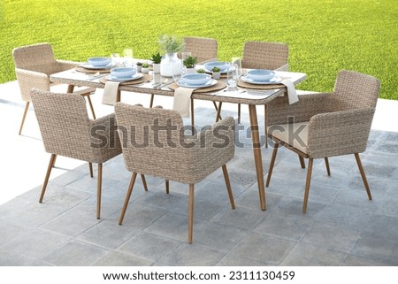 wooden outdoor table and chairs situated in a grassy backyard area with green foliage in the backdrop