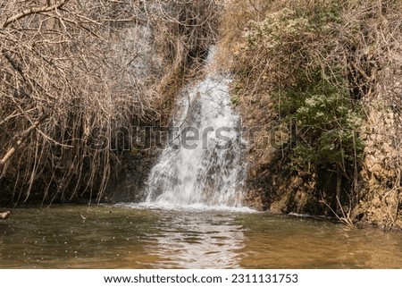 Small waterfall flows from a crevice in the mountain and is located in the continuation of the rapid, shallow, cold mountain Ayun river in the Galilee, near Metula city, in northern Israel